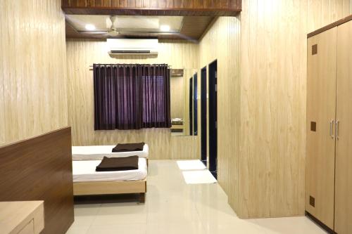 a room with two beds and a window in it at Hotel Midtown Inn in Trimbak