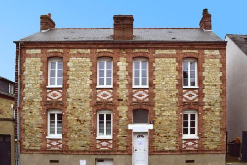 a red brick building with white windows and a door at Chez David et Bene in Rennes