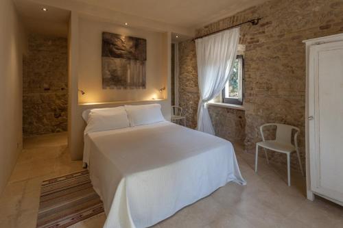a bedroom with a white bed and a window at Azienda Agricola Mandranova in Palma di Montechiaro