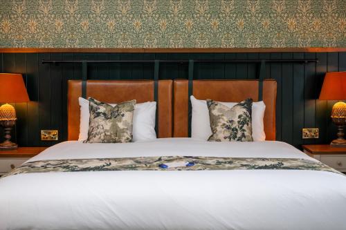 a bedroom with a large bed with two lamps at Himley House by Chef & Brewer Collection in Himley