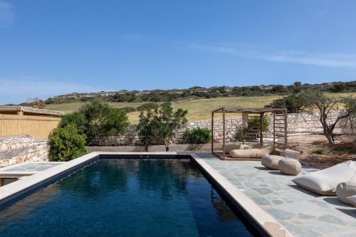 a swimming pool in the middle of a yard at Amalgam Homes Paros in Ambelas