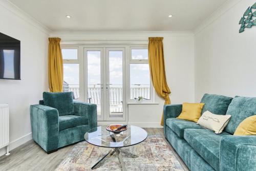 a living room with a couch and a chair and a table at Freshwater at the Aqua in Shanklin