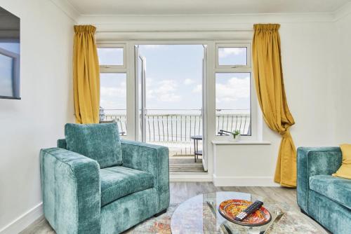 a living room with a couch and a chair and a table at Freshwater at the Aqua in Shanklin
