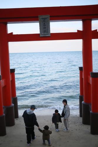 a group of people walking on the beach at bLOCAL KAI House - with Ocean view good for 8 PPL Free WiFi in Komatsu