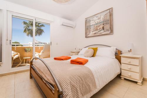 - une chambre avec un lit et des serviettes orange dans l'établissement Michele Apartment, à Jávea