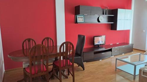 een eetkamer met een tafel en een rode muur bij Apartamento Pinseque in Pinseque