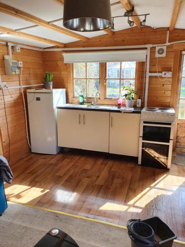 a kitchen with a refrigerator and a sink at The Cabin - a very quiet location in Pewsey