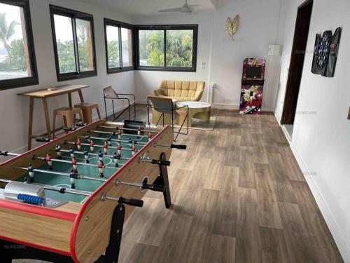 a living room with a foosball table in a room at Ocean-Villa 12 personnes avec piscine à 50m de la plage de l'Etang Salé Les Bains in Étang-Salé les Bains