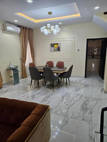 een woonkamer met een tafel en stoelen en een bank bij MDCUBE HOMES AND PROPERTIES in Ibadan