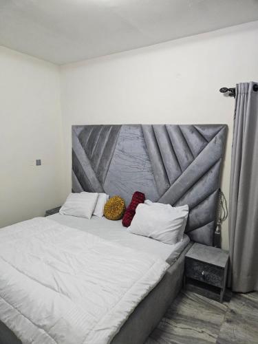 - un grand lit avec 2 oreillers dans l'établissement MDCUBE HOMES AND PROPERTIES, à Ibadan