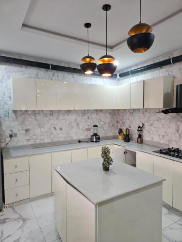 a kitchen with white cabinets and a white counter top at MDCUBE HOMES AND PROPERTIES in Ibadan
