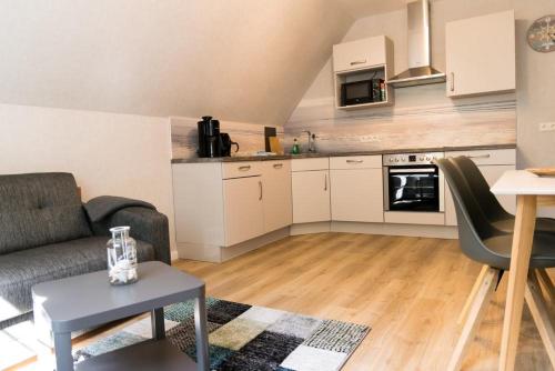 ein Wohnzimmer mit einem Sofa und einer Küche in der Unterkunft Friesenhof Jöns in Garding