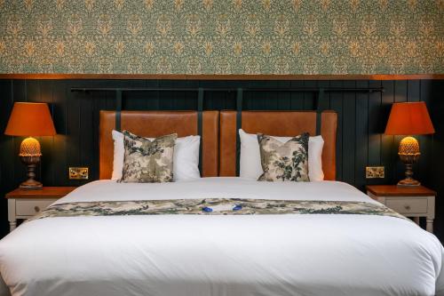a bedroom with a large bed with two lamps at Himley House by Chef & Brewer Collection in Himley