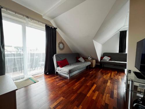 a living room with a couch and a large window at Apartamenty Liliowa 3 in Dębki