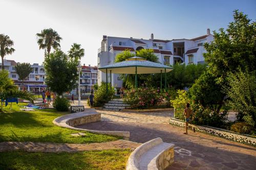 a park with an umbrella and some buildings at Apartments Kione Playa Romana Park in Alcossebre
