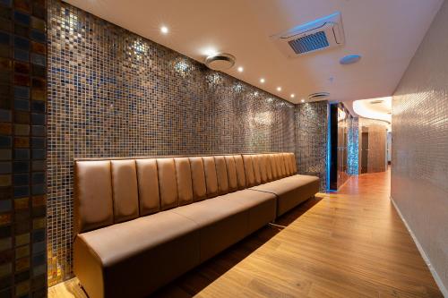 a waiting room with a leather bench against a brick wall at Hotel De‘Andros Virpazar in Virpazar