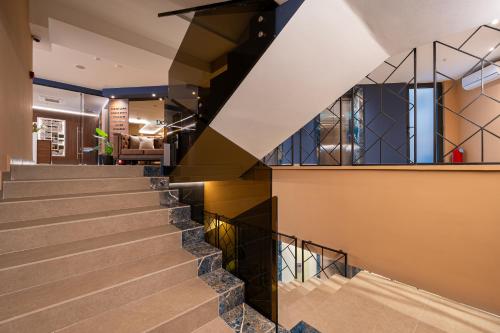 a staircase in a house with a black railing at Hotel De‘Andros Virpazar in Virpazar