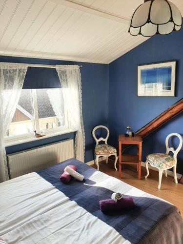 ファルケンベリにあるGits Gardの青い壁のベッドルーム1室、ベッド1台(椅子2脚付)