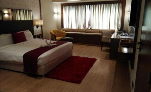 Habitación de hotel con cama y sala de estar. en Hotel Grand Canyon en Raipur