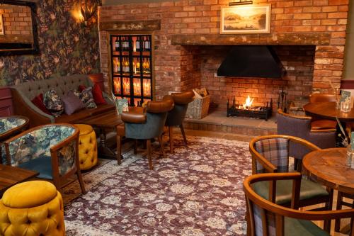 a restaurant with a fireplace and tables and chairs at Himley House by Chef & Brewer Collection in Himley