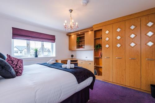 Great MittonにあるDamson House- Spacious, Modern 6 bedroom Executive House - Ideal for Work Teams or Multi-Generational Familiesの大きなベッドと木製のキャビネットを備えた寝室