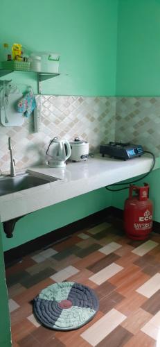 a kitchen with a sink and a plate on the floor at Rakkīhömu in San Felix