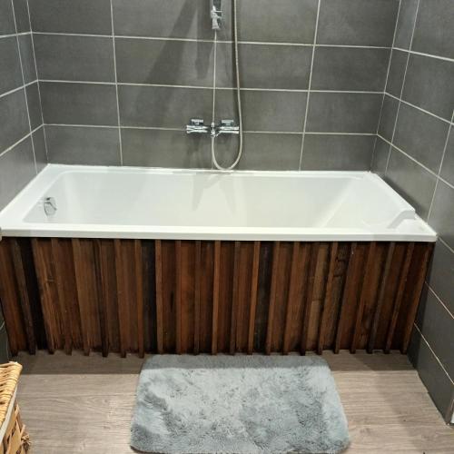 une baignoire avec douche et un tapis dans une salle de bain dans l'établissement Maison bord de mer, à Penta-di-Casinca