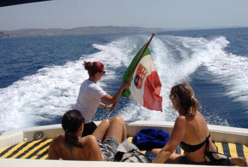 a group of people on a boat with a flag at Azienda Agricola Mandranova in Palma di Montechiaro