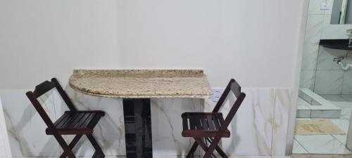 duas cadeiras sentadas ao lado de uma mesa com um balcão em AP CENTRAL VIP em Campina Grande