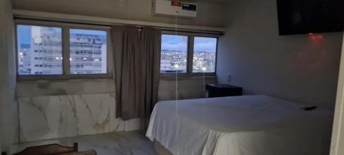 um quarto com uma cama branca e 2 janelas em AP CENTRAL VIP em Campina Grande