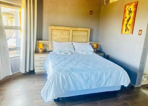 a bedroom with a large bed with white sheets and pillows at Elias Nefale Eco Estate in Mitxetweni