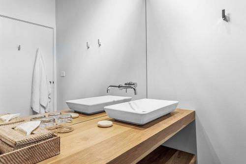 a bathroom with two white sinks on a wooden counter at Luxury Villa 13 Within Bangalay in Shoalhaven Heads