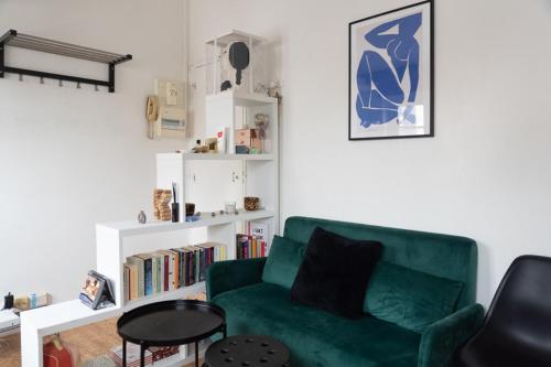 - un salon avec un canapé vert et une table dans l'établissement Beautiful Apartment In The Heart Of Paris, à Paris
