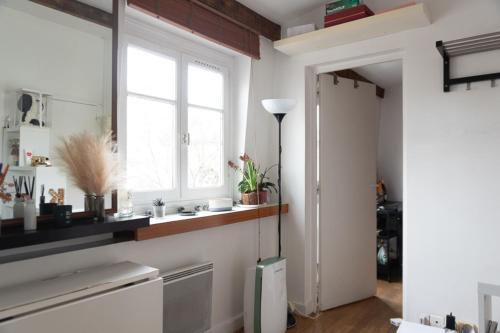 d'une cuisine aux murs blancs, d'une fenêtre et d'une porte. dans l'établissement Beautiful Apartment In The Heart Of Paris, à Paris