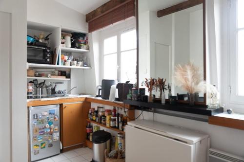 une cuisine avec un réfrigérateur blanc et une fenêtre dans l'établissement Beautiful Apartment In The Heart Of Paris, à Paris