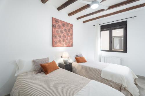 a bedroom with two beds and a window at El Secret De Marco in Vall dʼAlba