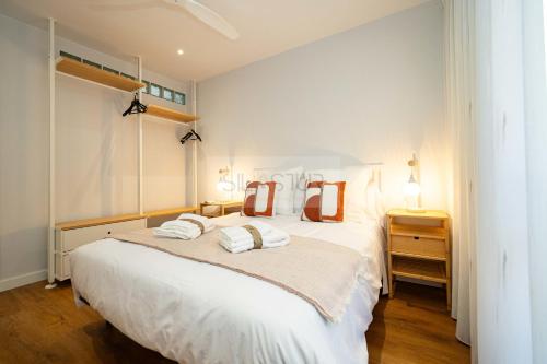Un dormitorio con una gran cama blanca con dos almohadas. en Casa Andrés Apartamento, en Oviedo