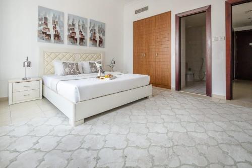 a bedroom with a large white bed and a bathroom at Frank Porter - V3 Tower in Dubai