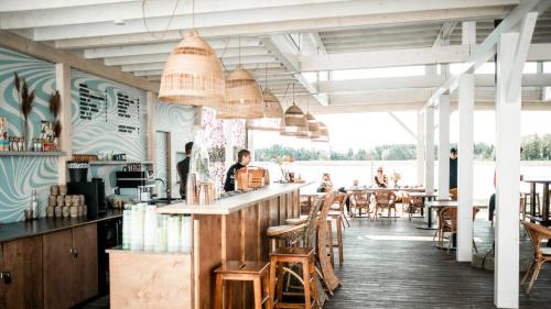 a restaurant with a bar with people sitting at it at Sunset Bungalow in Orissaare