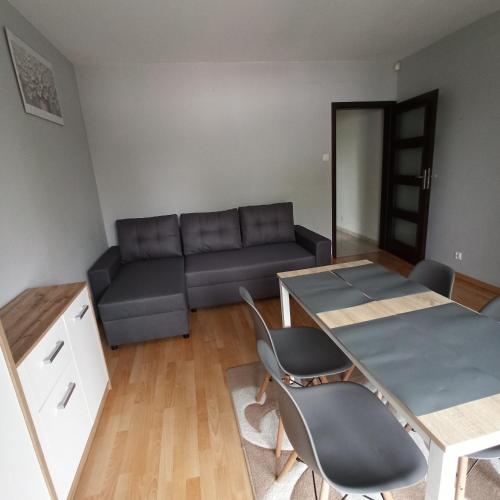 a living room with a couch and a table and chairs at Apartament Dunikowskiego 57m2 in Lublin