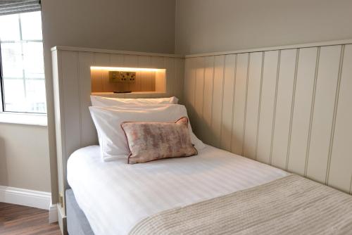 a small bedroom with a bed with a pillow on it at Urban Nest Townhouse in Galway