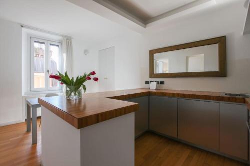 a kitchen with a counter with a mirror and a table at HACCA Collection - Brera & Fashion District - Bright 2BR Apt in Milan