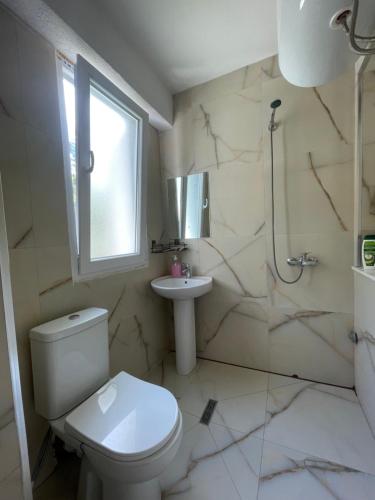 łazienka z toaletą i umywalką w obiekcie BUJTINA IZET SELIMAj w mieście Valbonë