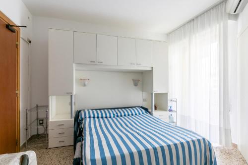 sypialnia z łóżkiem z niebiesko-białymi paskami w obiekcie Luxemburg w Caorle