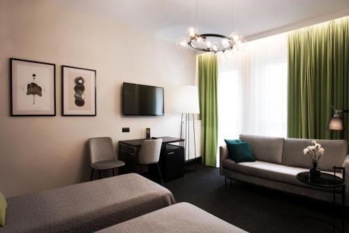 um quarto de hotel com um sofá e uma mesa em Hotel Atrium em Cracóvia