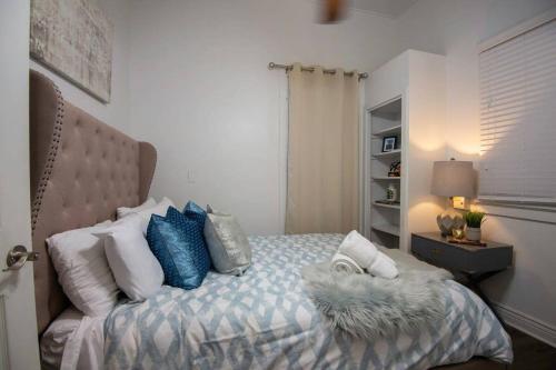 a bedroom with a bed with blue and white pillows at 5 BR - Sleeps 8! Steps from Bourbon Street! in New Orleans