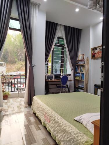 Schlafzimmer mit einem Bett, einem Schreibtisch und einem Fenster in der Unterkunft Home stay 72 in Diện Biên Phủ