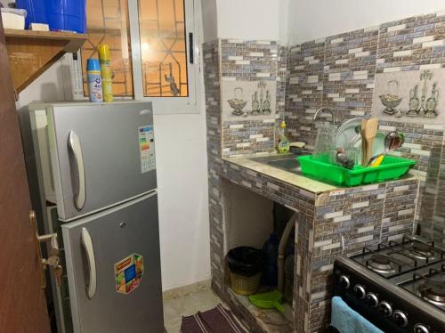a small kitchen with a sink and a refrigerator at Résidence l'endroit in Abidjan
