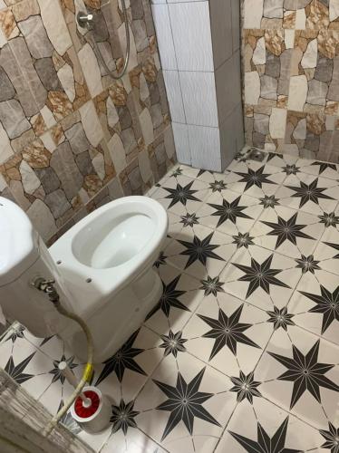 La salle de bains est pourvue de toilettes avec des étoiles. dans l'établissement Résidence l'endroit, à Abidjan