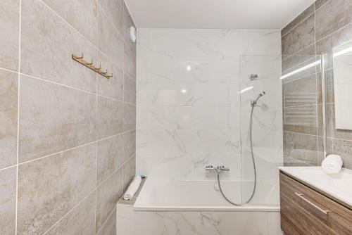 uma casa de banho com um chuveiro, uma banheira e um lavatório. em White Pearl A03 - Alpes Travel - Central Chamonix - Sleeps 2-4 em Chamonix-Mont-Blanc